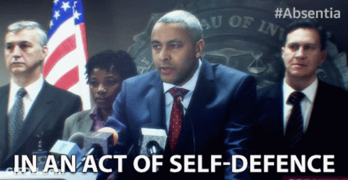 Man In Suit At Podium In An Act Of Self-Defense GIF