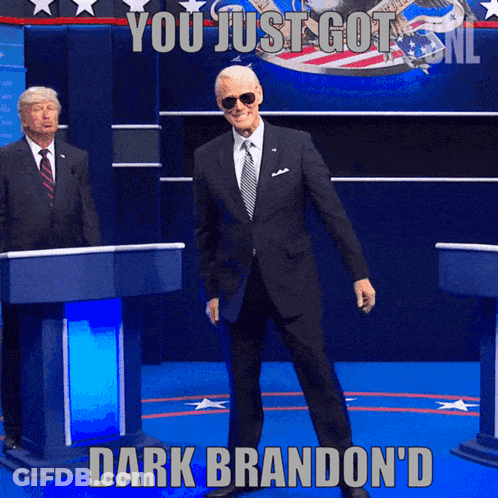 Man In Suit At Podium Saying You Just Got Dark Brandon'd GIF