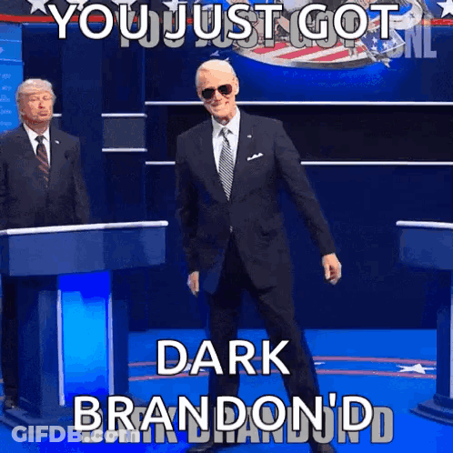 Man In Suit At Podium Saying You Just Got Dark Brandon GIF
