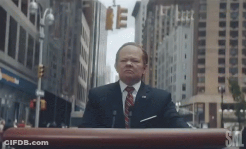 Man In Suit At SNL Podium GIF