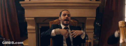 Man In Suit At Table With Champagne Glasses GIF