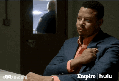 Man In Suit At Table With Empire Hulu On Screen GIF