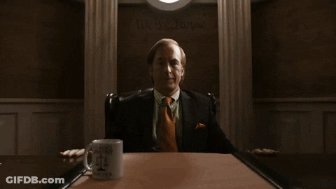 Man In Suit At Table With Justice Mug GIF