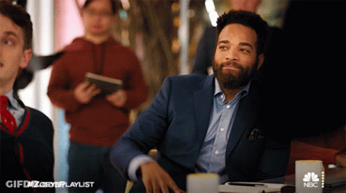 Man In Suit At Table With NBC GIF