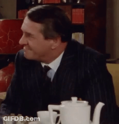 Man In Suit At Table With White Teapot GIF