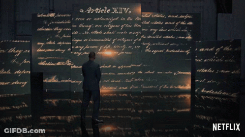 Man In Suit Before Wall Of Handwritten Article XIV GIF