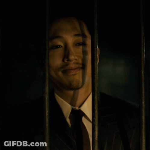 Man In Suit Behind Bars Eyes Closed GIF