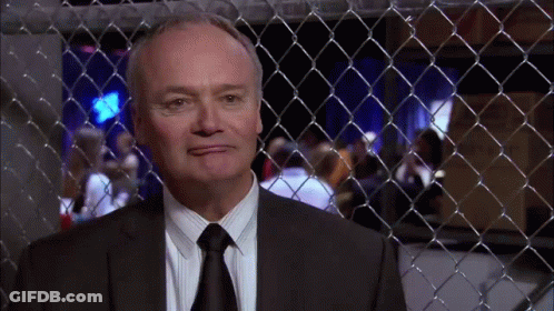 Man In Suit Behind Fence GIF