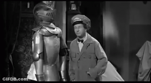 Man In Suit Beside Knight In Armor GIF