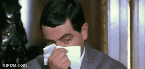Man In Suit Blowing Nose With Napkin GIF