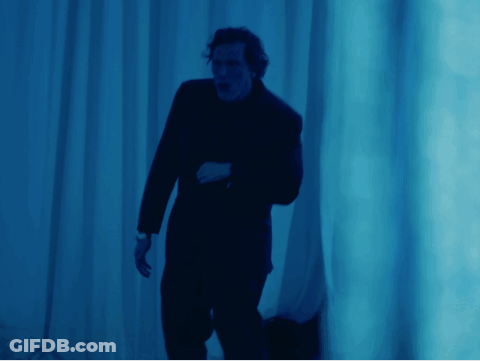 Man In Suit By Blue Wall GIF