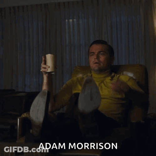 Man In Suit By Sign That's A GIF