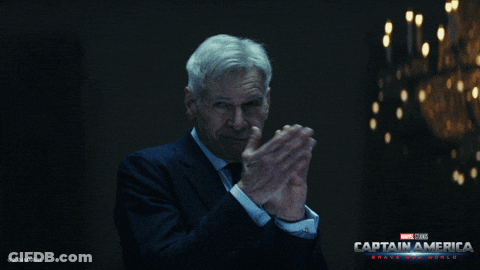 Man In Suit Clapping In Front Of Captain America Poster GIF