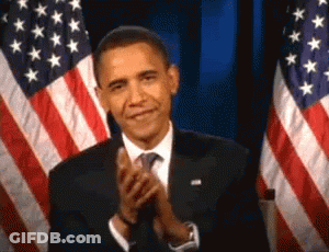 Man In Suit Clapping In Front Of Two American Flags GIF