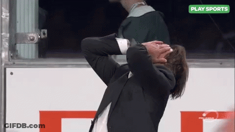 Man In Suit Covering Face At Sports Sign GIF
