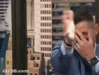 Man In Suit Covering Face Before City Skyline GIF