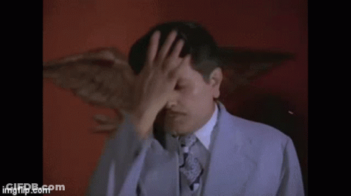 Man In Suit Covering Face GIF