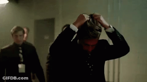 Man In Suit Covering Face While Walking GIF