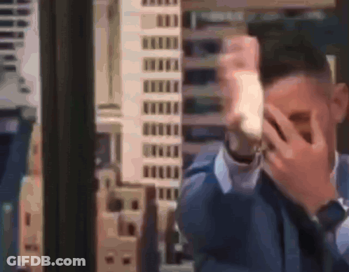 Man In Suit Covering Face With Hands GIF