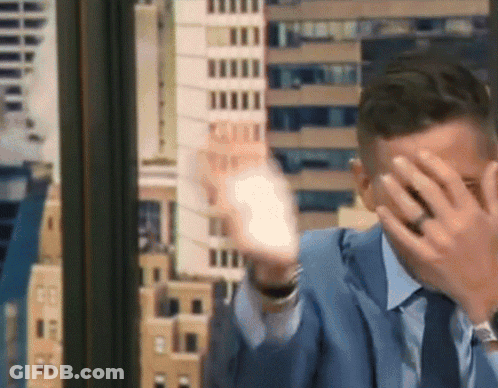 Man In Suit Covering Face With Hands GIF