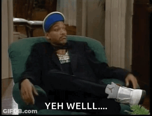 Man In Suit Crossed Legs Saying Yeh Well GIF