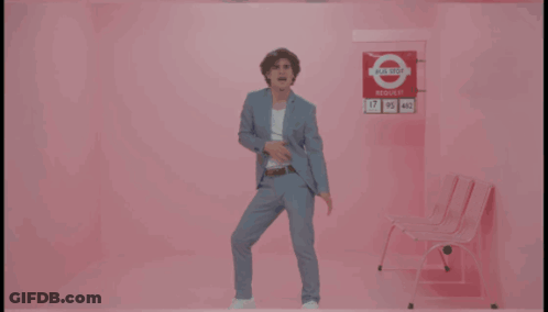 Man In Suit Dancing By Pink Wall I Need Your Love GIF