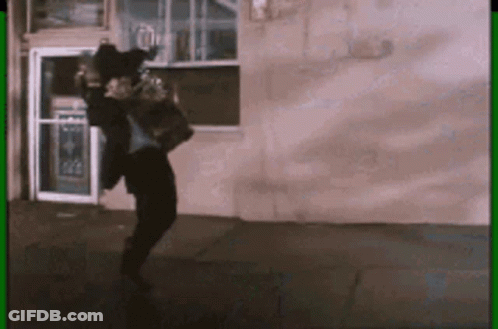 Man In Suit Dancing In Front Of Building With Green Border GIF