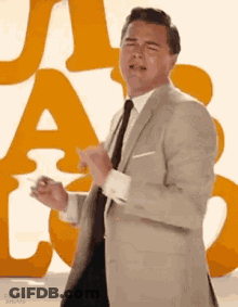 Man In Suit Dancing In Front Of Orange Letter GIF