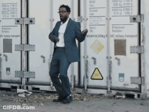 Man In Suit Dancing In Front Of UIC Railway Container GIF