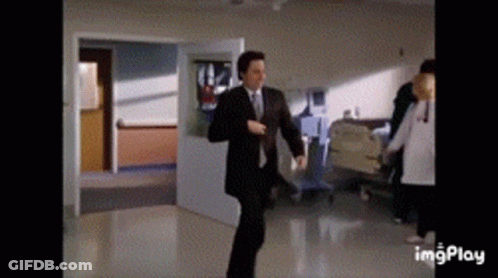 Man In Suit Dancing In Hospital Hallway GIF
