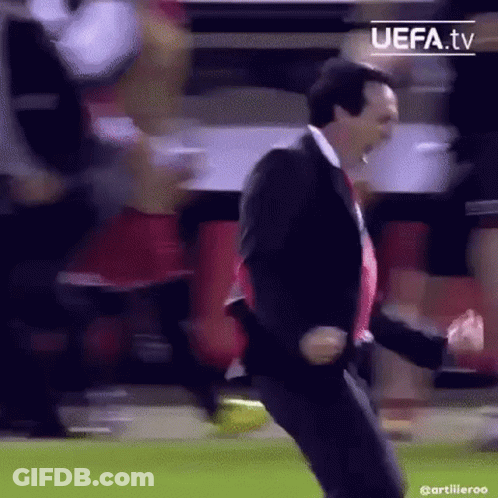 Man In Suit Dancing On Soccer Field With Crowd GIF