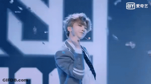 Man In Suit Dancing On Stage With Microphone GIF