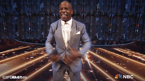 Man In Suit Dancing On Stage With NBC Logo GIF