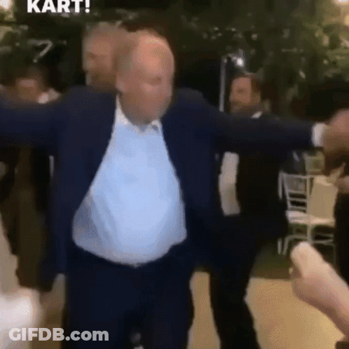 Man In Suit Dancing With Arms Outstretched In Crowd GIF