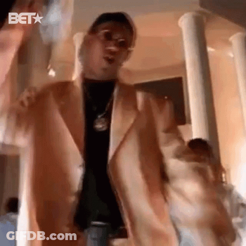 Man In Suit Dancing With Money Bag In Columned Room GIF