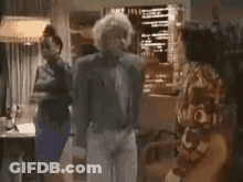 Man In Suit Dancing With Two Women Behind GIF