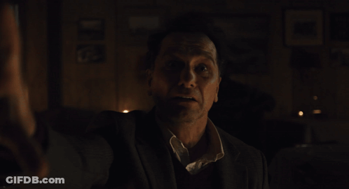 Man In Suit Dark Room With Saint Picture GIF