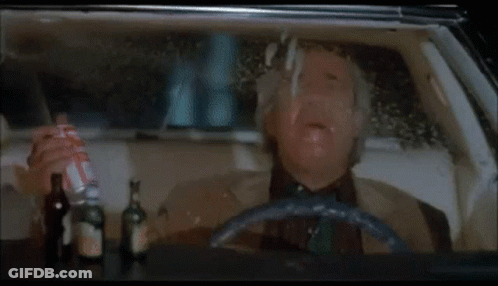 Man In Suit Driving Car At Night Making Funny Face GIF