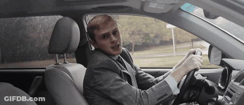 Man In Suit Driving Car Making Funny Face GIF