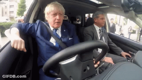 Man In Suit Driving Car With Another Man In Back GIF