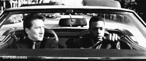 Man In Suit Driving Car With Another Man In Back GIF