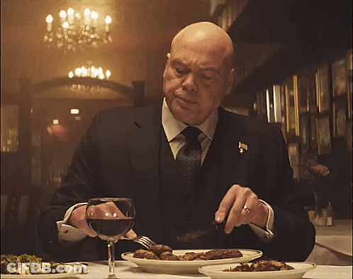 Man In Suit Eating At Table GIF