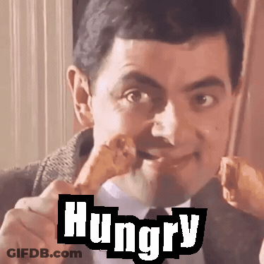 Man In Suit Eating Chicken With Hungry Behind Him GIF