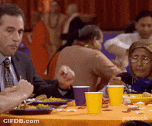Man In Suit Eating Food At Table GIF