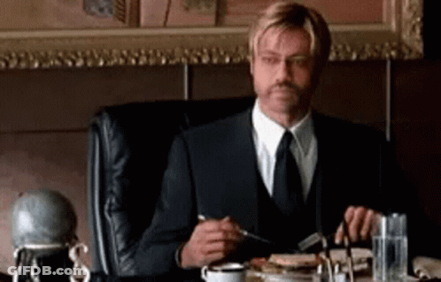Man In Suit Eating Meal At Table GIF