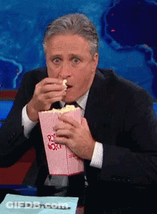 Man In Suit Eating Popcorn From Pink Box GIF