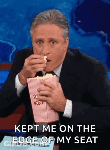 Man In Suit Eating Popcorn Saying Kept Me On The Edge Of My Seat GIF