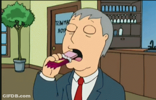 Man In Suit Eating Snack In Front Of T2M Mac Door GIF