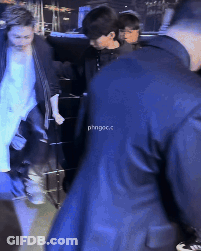 Man In Suit Escorted By Man In Black Jacket Saying Phngoc.C GIF