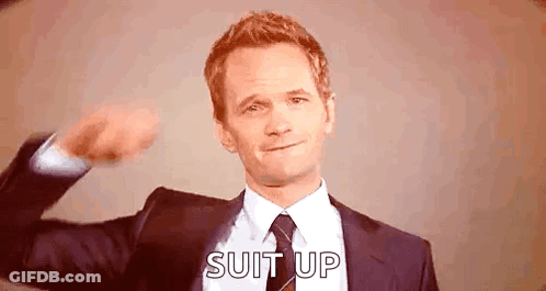 Man In Suit Flexing Muscles Says Suit Up GIF